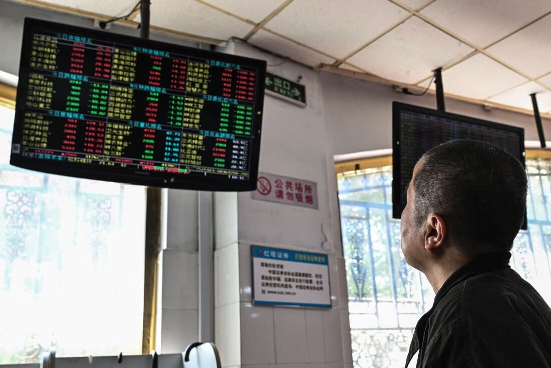 Investidores monitoram os movimentos dos preços das ações em Xangai, China