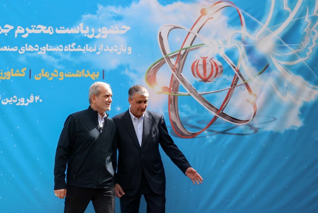 O presidente Masoud Pezeshkian (E) e o chefe da Organização de Energia Atômica do Irã (AEOI), Mohammad Eslami (D)