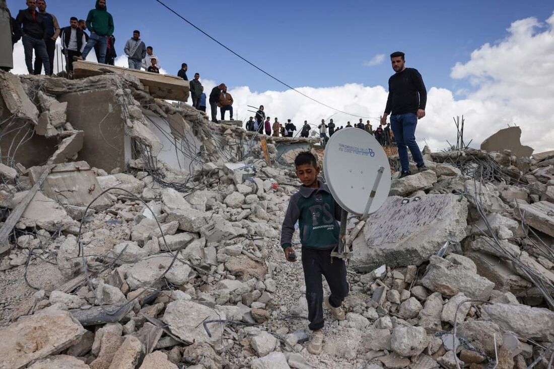 Palestinos da família Al-Hirsh recuperam pertences das ruínas de suas casas após serem demolidas por tratores israelenses