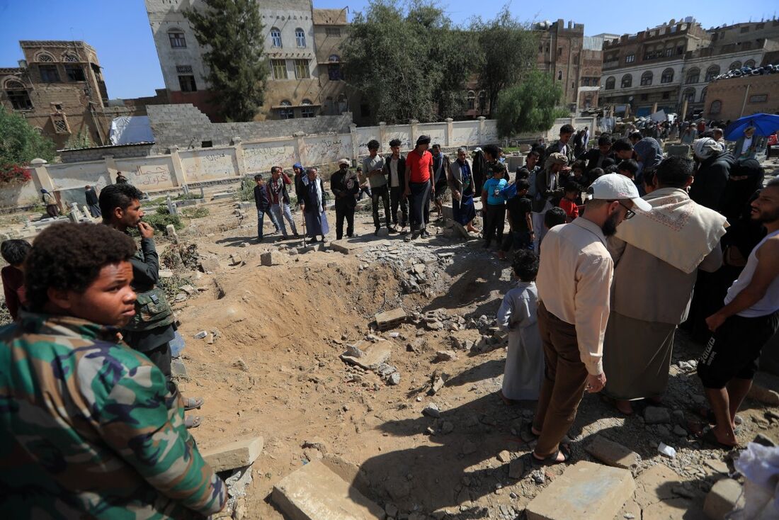 Pessoas avaliam os danos causados por um suposto ataque na capital do Iêmen, Sanaa, controlada pelos huthis