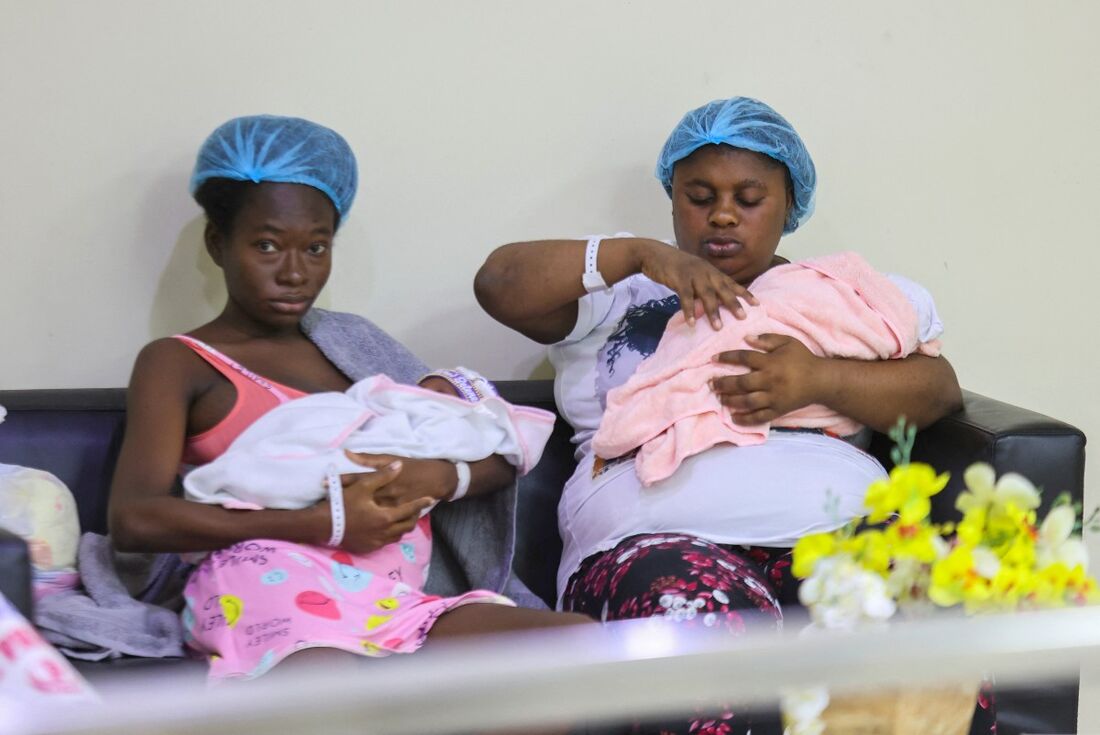 Duas mulheres carregando seus filhos são fotografadas no hospital em Santo Domingo, em 21 de abril de 2025.