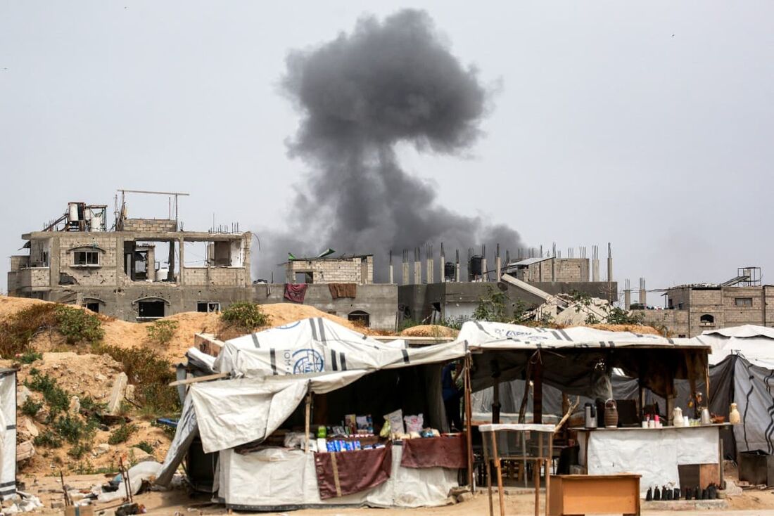 Uma coluna de fumaça sobe do bombardeio israelense contra um prédio em Beit Lahia, no norte da Faixa de Gaza, em 24 de abril de 2025.