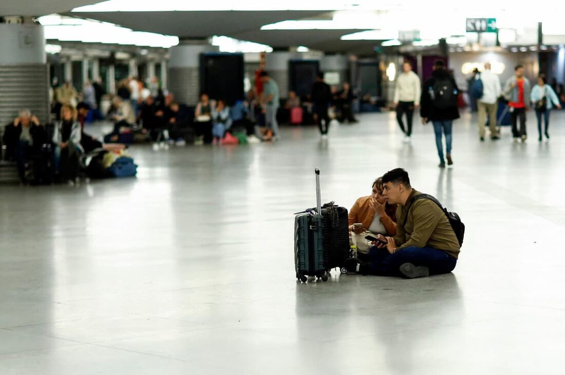 Passageiros na estação ferroviária de Atocha sentem os efeitos do apagão que afetou toda a Península Ibérica e o sul da França, em Madri, em 28 de abril de 2025.