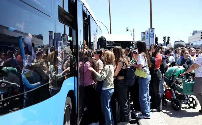 Pessoas embarcam em ônibus em frente à estação de trem Atocha, em Madri, após seu fechamento devido ao grande apagão que atingiu a Espanha 