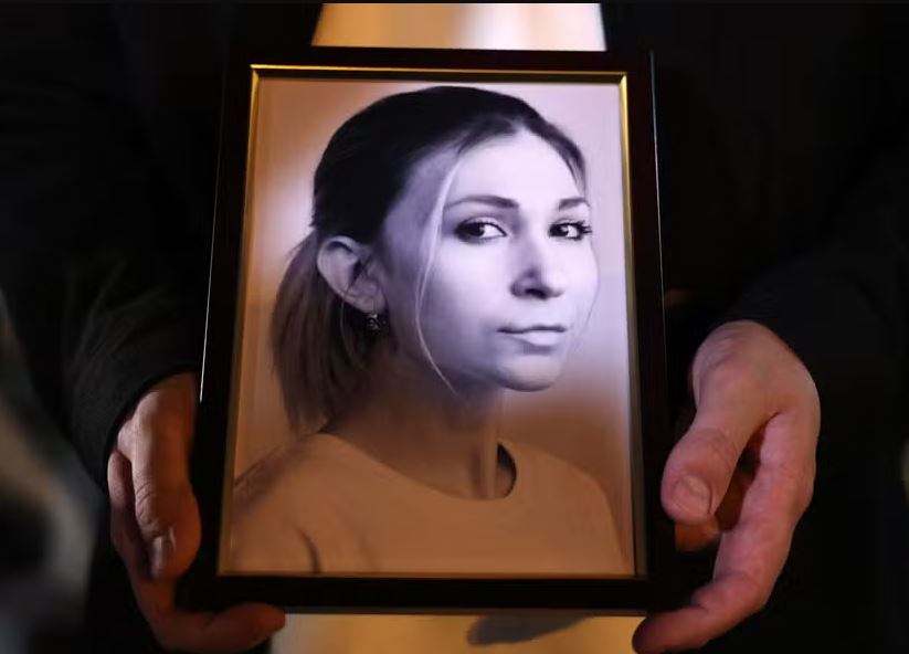 Colega da jornalista Victoria Roshchyna segura foto dela durante memorial em Kiev 