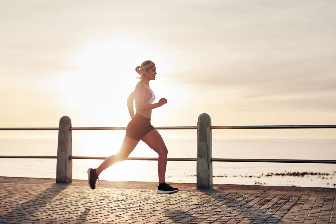 Mulher correndo ao entardecer