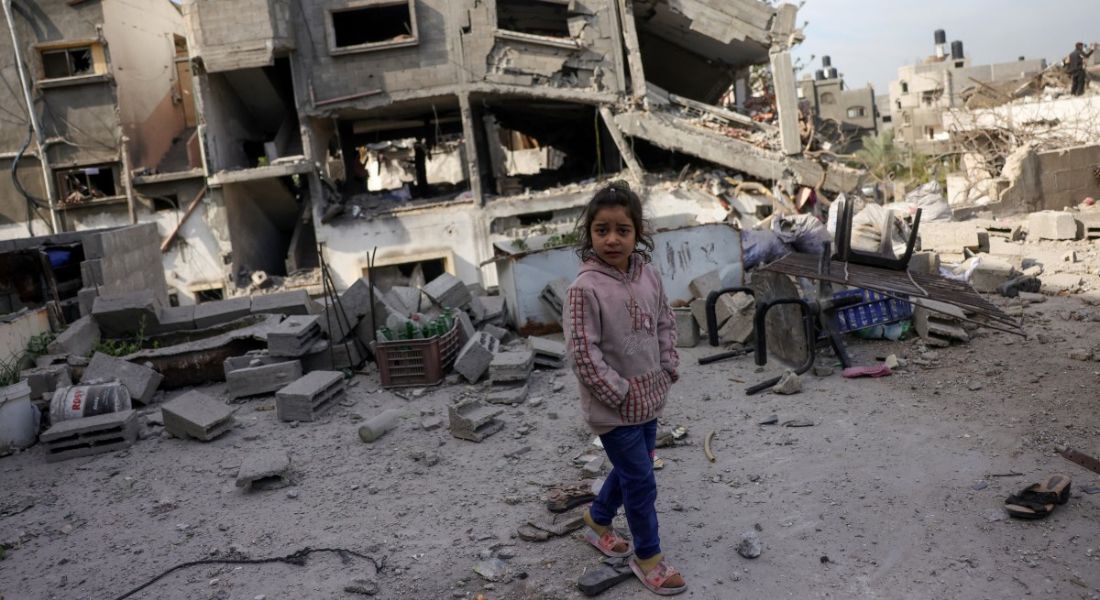 Criança caminha diante de destroços na Faixa de Gaza após ataque israelense