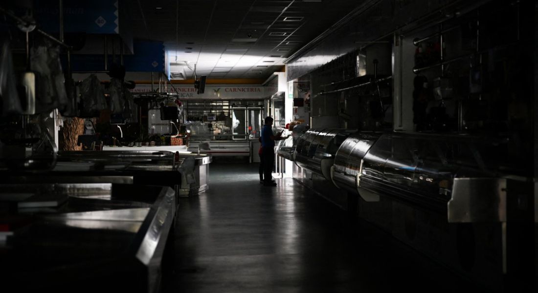 Um homem e uma criança caminham por um mercado local durante um grande apagão em Vigo, na Espanha
