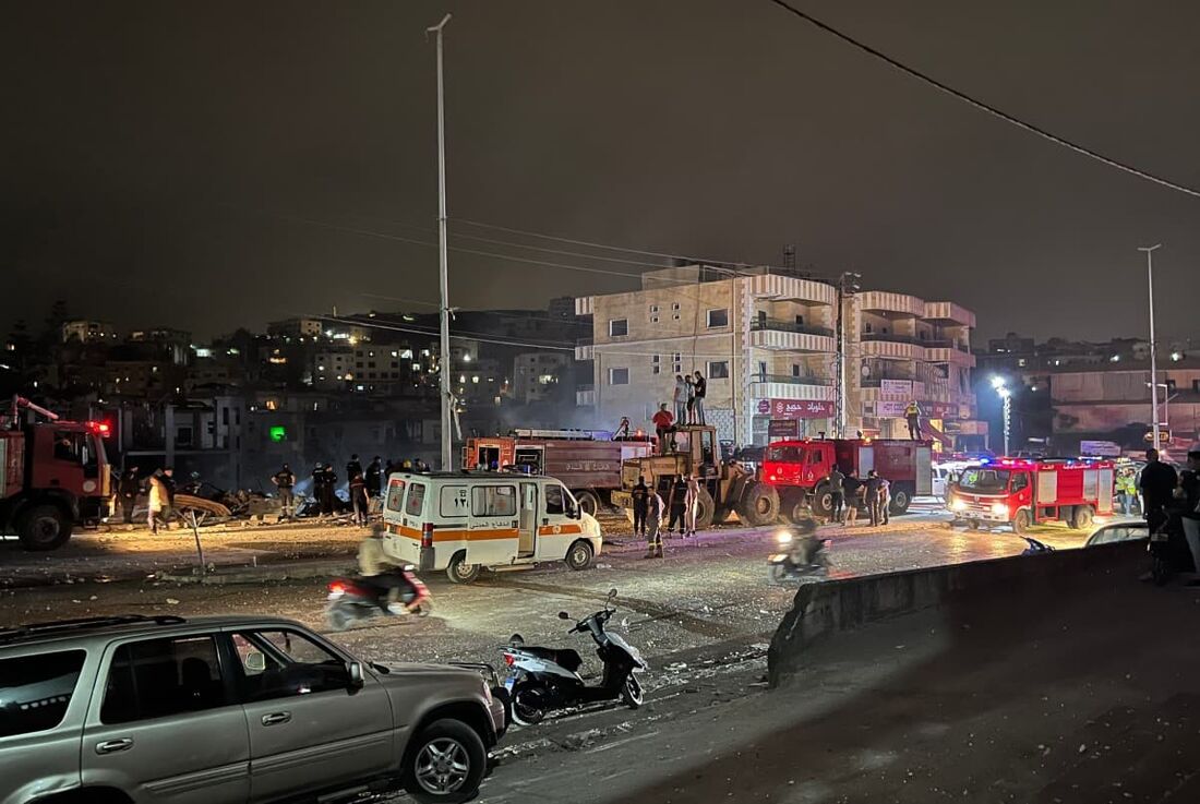 Bombeiros e socorristas se reúnem no local de um ataque aéreo israelense que teve como alvo um prédio na cidade de Toul, no sul do Líbano