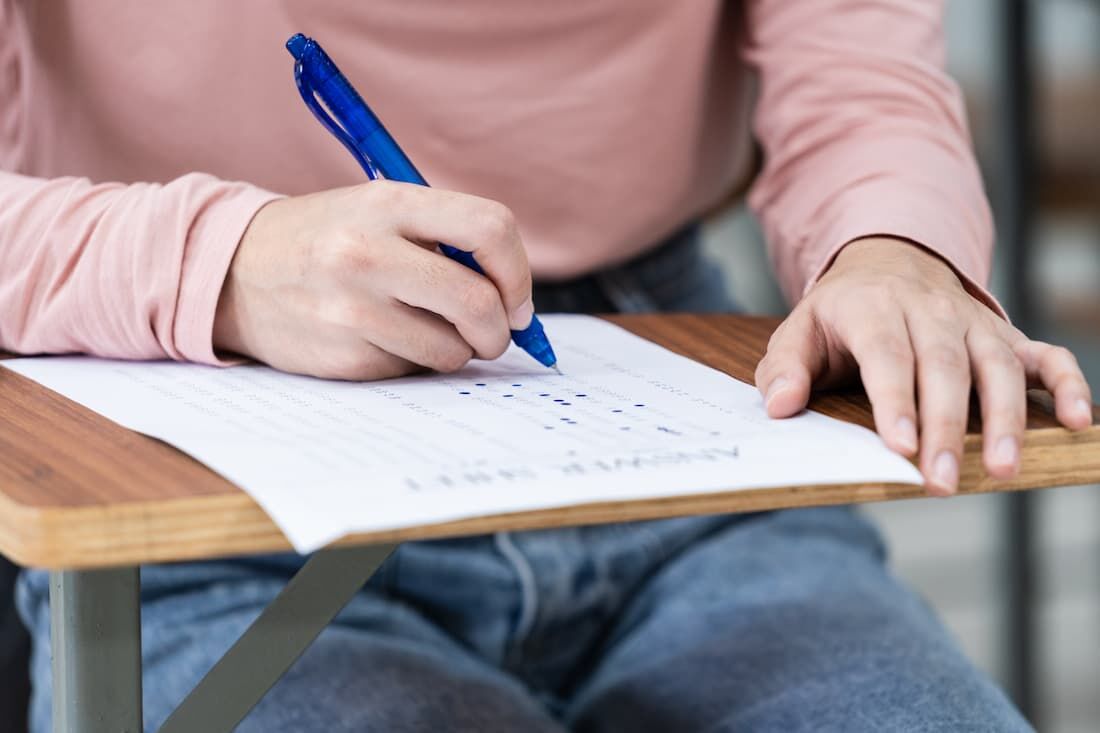 Estudante preenchendo gabarito de prova de concurso