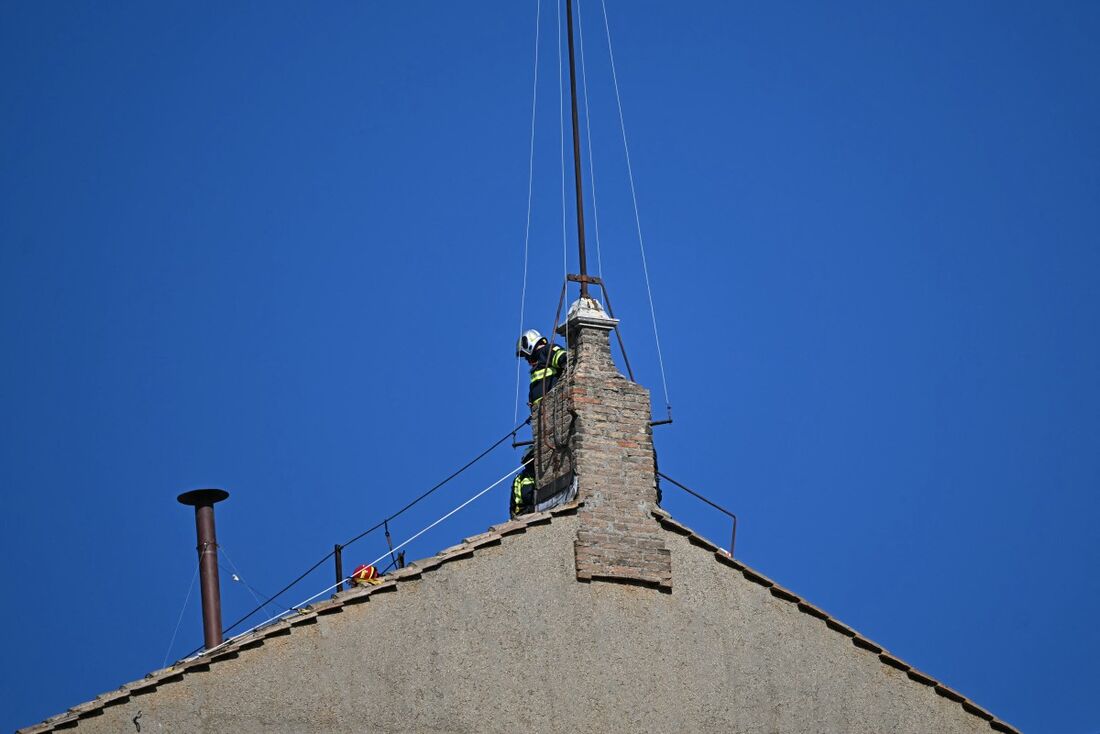 Esta fotografia mostra uma vista da chaminé (E) no telhado da Capela Sistina, enquanto ela está sendo instalada no Vaticano, em 2 de maio de 2025'