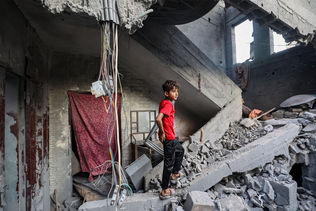 Uma criança em meio aos escombros de um prédio atingido por um ataque israelense no campo de refugiados palestinos de Bureij, no centro da Faixa de Gaza