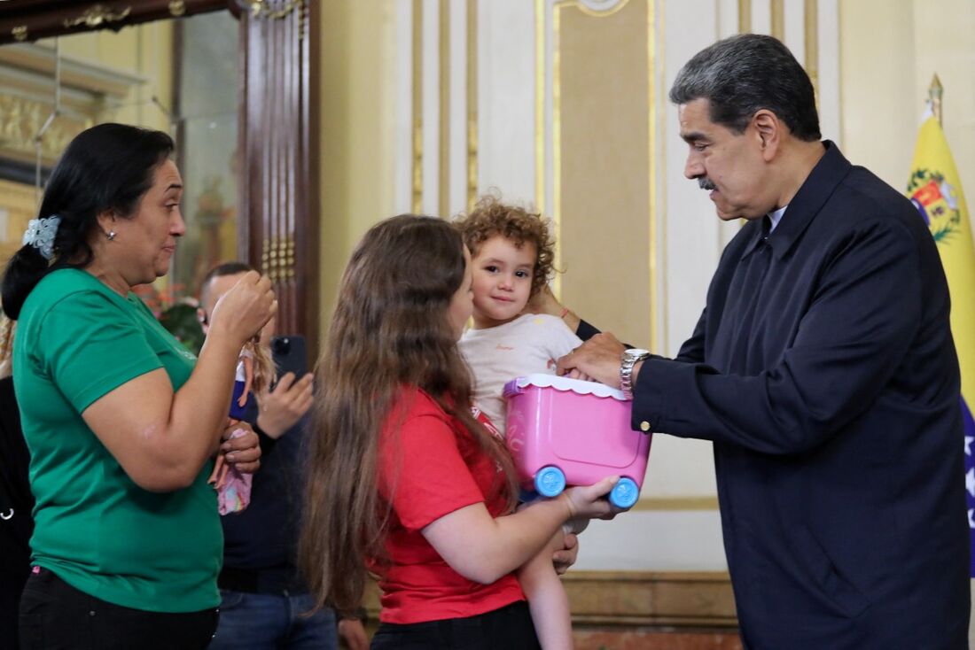 O presidente da Venezuela, Nicolás Maduro (à direita), conversando com Yorelys Bernal (ao centro), segurando sua filha, Maikelys Espinoza, no palácio presidencial de Miraflores, em Caracas, em 14 de maio de 2025.