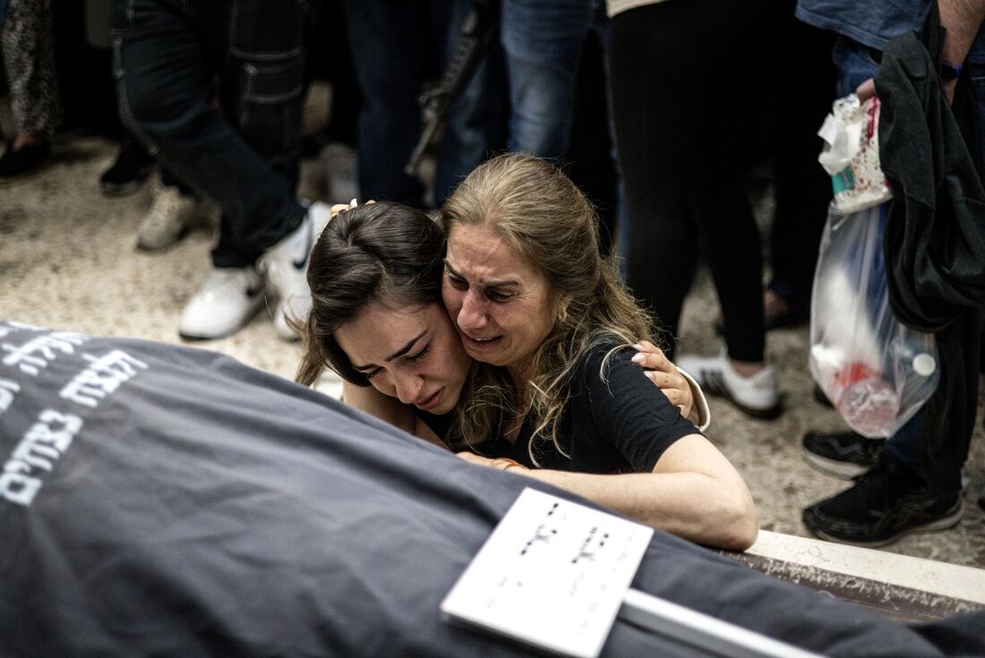 Familiares em luto, em 15 de maio de 2025, ao lado do corpo envolto em manto de Tzala Gaz