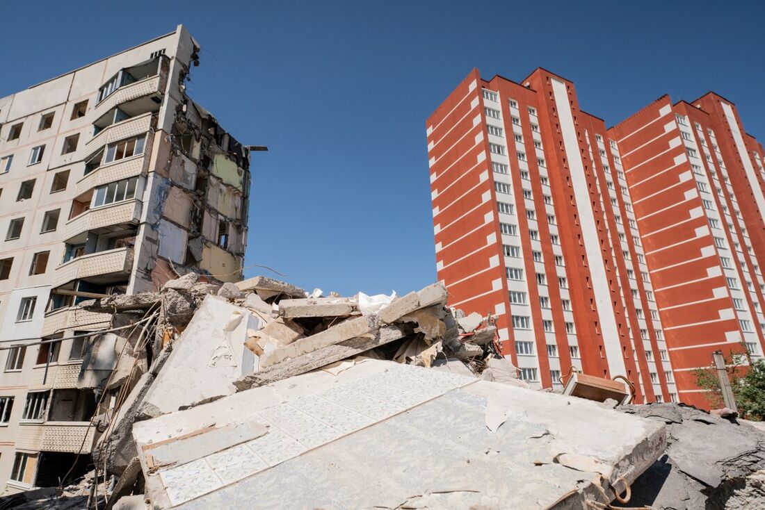 edifício residencial recém-construído (à direita) ao lado de um edifício residencial que foi destruído por um ataque com mísseis em 2022