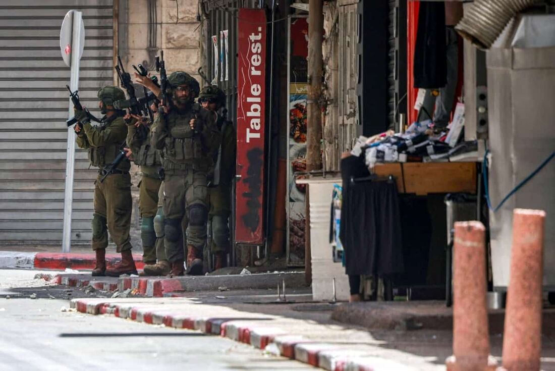 Soldados do exército israelense tomam posições durante um ataque no coração da cidade palestina de Nablus, na Cisjordânia ocupada