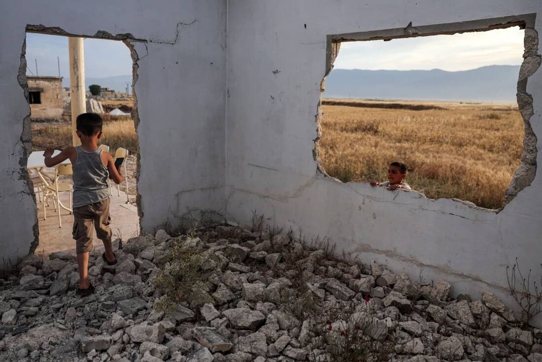 Crianças brincam em uma casa destruída na vila de al-Hawash, na província de Hama, centro-oeste da Síria