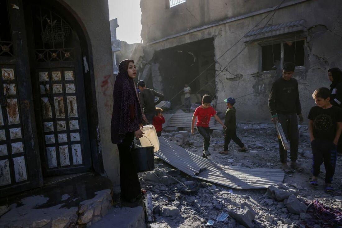 Pessoas verificam o local de um ataque israelense noturno, em Jabalia, no centro da Faixa de Gaza