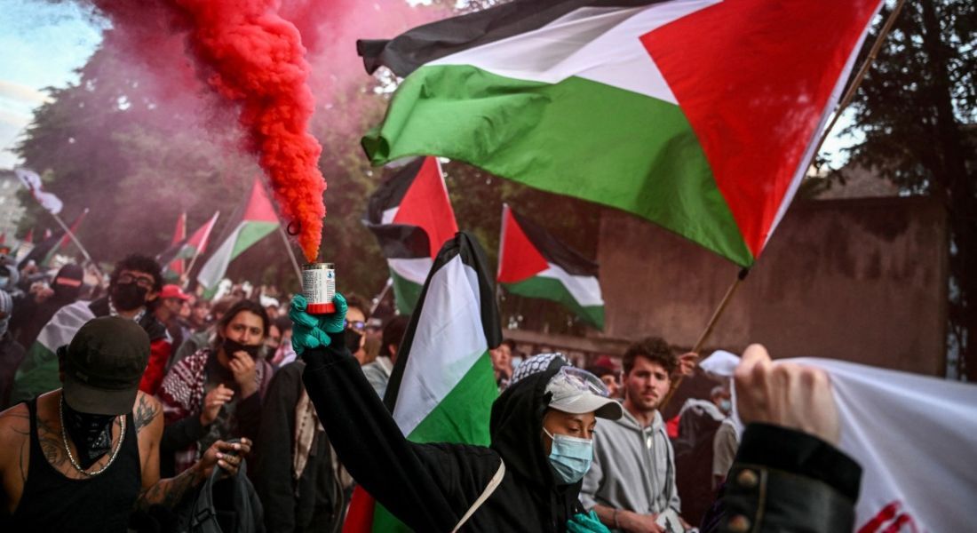 Manifestantes pró-palestina agitam bandeiras palestinas e acendem sinalizadores durante uma manifestação contra Israel, em Basileia