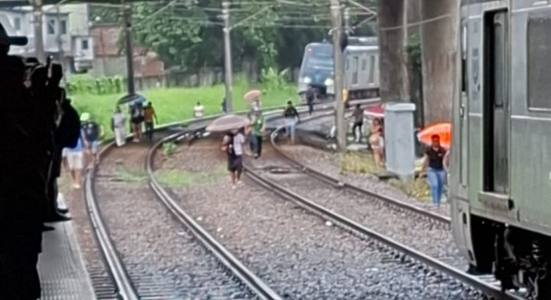 Passageiros andando sobre trilhos no Metrô do Recife após trem quebrar