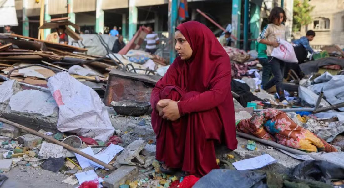 Mulher palestina em escombros da escola Fahmi al-Jarjawi, bombardeada por Israel nesta segunda