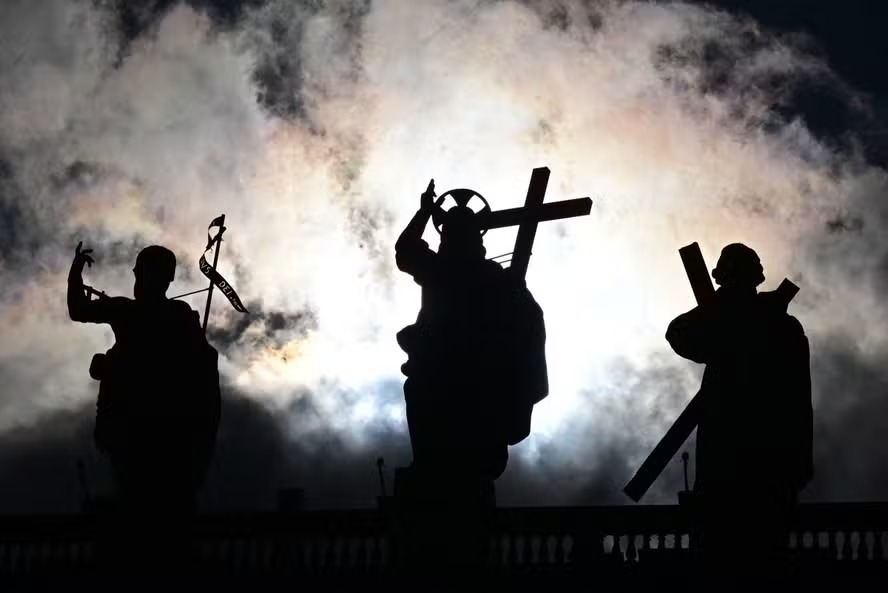 Estátuas da basílica são vistas em silhueta enquanto o conclave para eleger um novo Papa começa, na Praça de São Pedro, Vaticano 