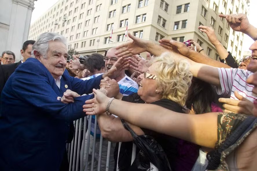 Então presidente do Uruguai, José Mujica cumprimenta pessoas nas ruas de Santiago, após encontro com o o então presidente chileno, Sebastián Piñera