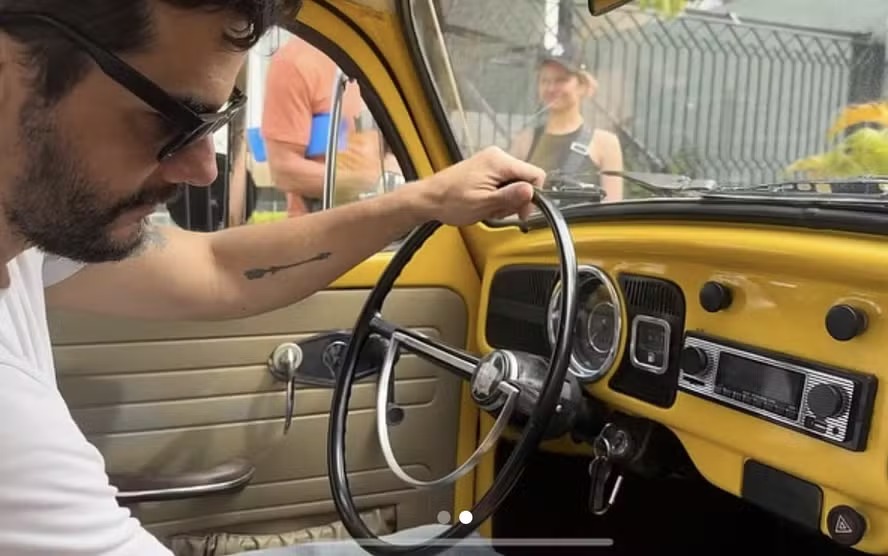 O ator Wagner Moura dirige um Fusca nas filmagens de 'O agente secreto' 