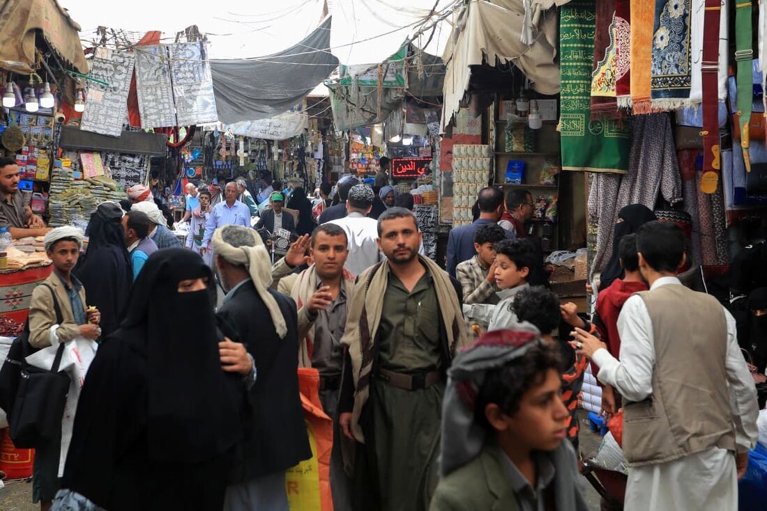Iemenitas se reúnem em um mercado popular em Sanaa para comprar comida, doces e roupas novas em 3 de junho de 2025