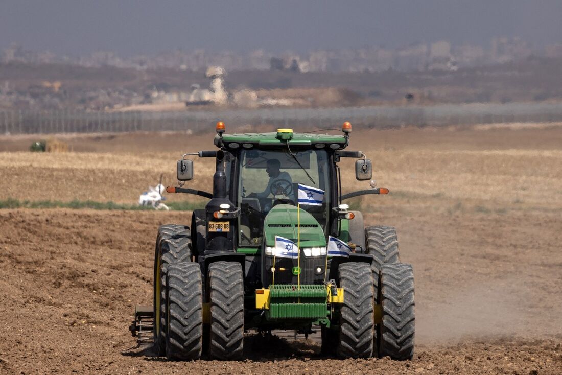 Um fazendeiro dirige um trator ao longo de um campo agrícola perto da fronteira sul de Israel com a Faixa de Gaza em 21 de maio de 2025.