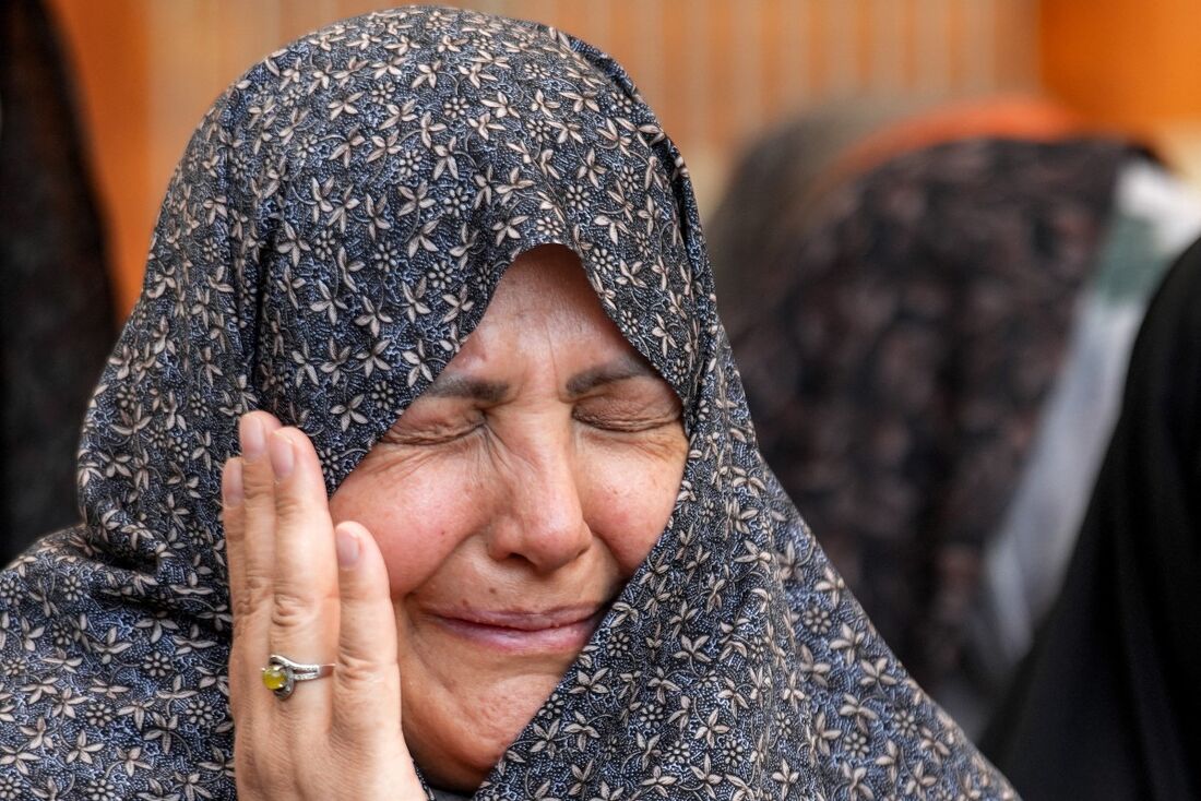 Uma fiel muçulmana reage enquanto reza com outros peregrinos iranianos que visitam o Santuário Imam Ali na cidade sagrada de Najaf, no centro do Iraque, após os ataques de Israel ao Irã no início do dia.