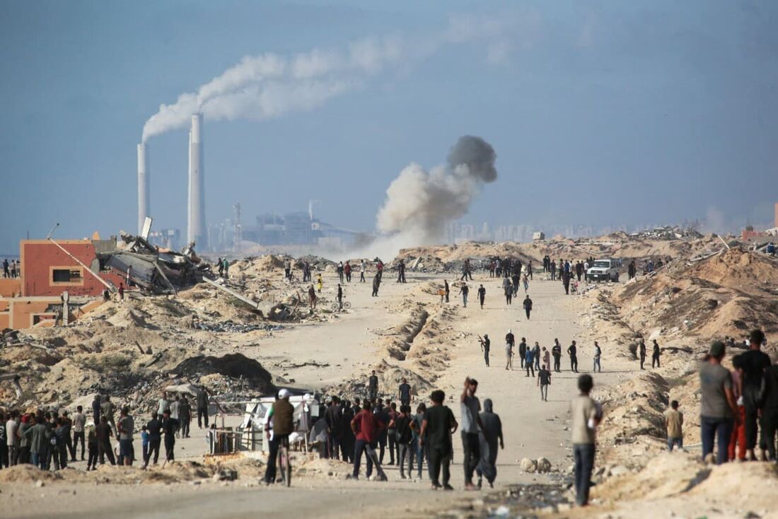 Deslocados reunidos ao redor de um veículo da ONU que acompanha caminhões que transportam ajuda humanitária para a Faixa de Gaza