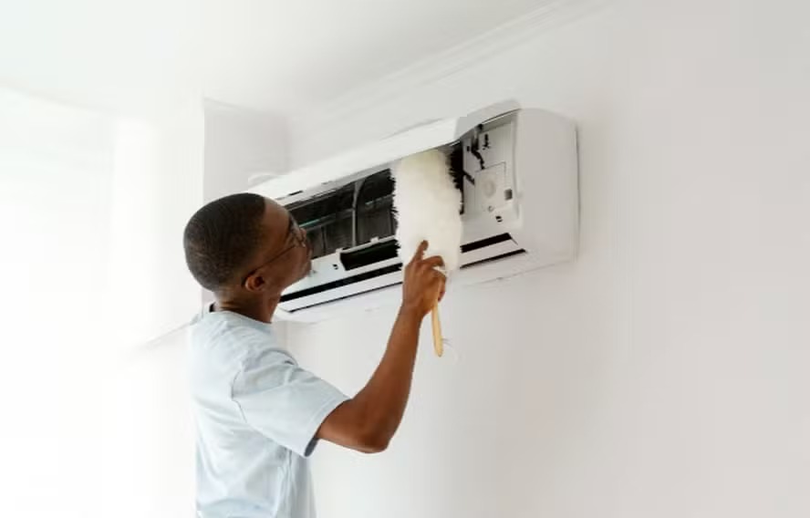 Homem limpa ar condicionado