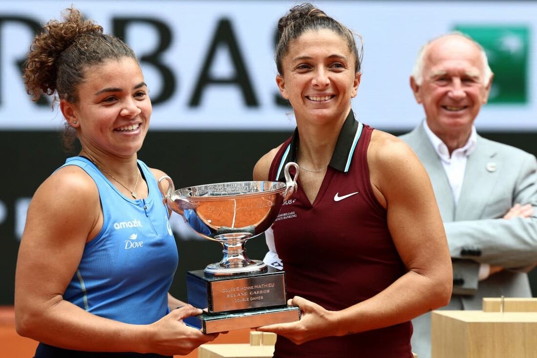 As italianas Jasmine Paolini (E) e Sara Errani posam com seu troféu após vencerem a final de duplas femininas em Roland Garros