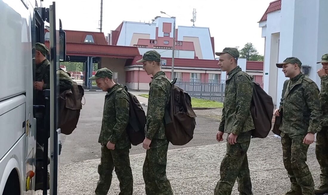 Prisioneiros de guerra russos embarcam em um ônibus após uma troca em um local não revelado na Bielorrússia.