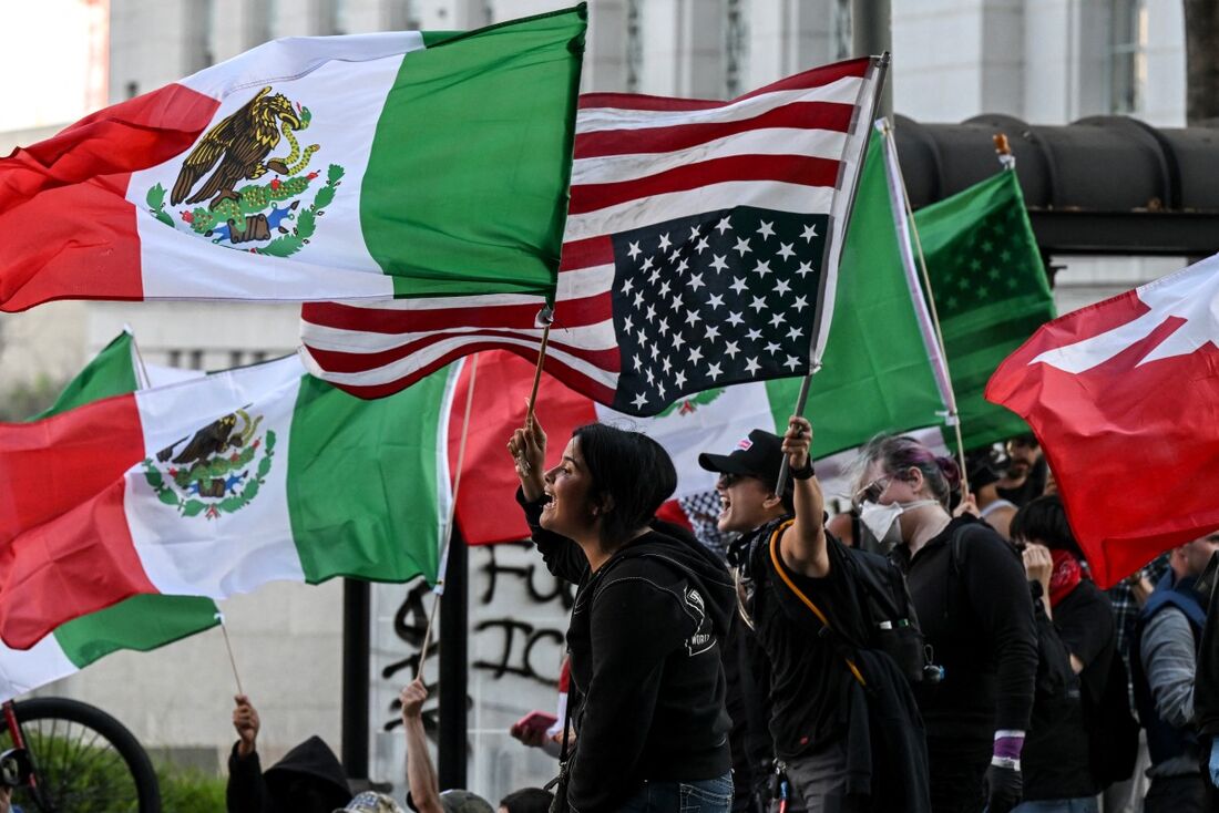 Manifestantes com a bandeira dos Estados Unidos e do México durante protesto em Los Angeles