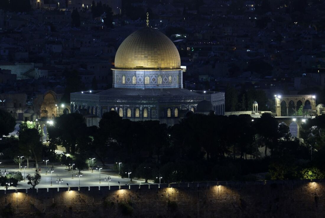 Esta foto tirada do Monte das Oliveiras mostra o Domo dentro do complexo da Mesquita de Al-Aqsa, em Jerusalém, ao pôr do sol de 14 de junho de 2025.
