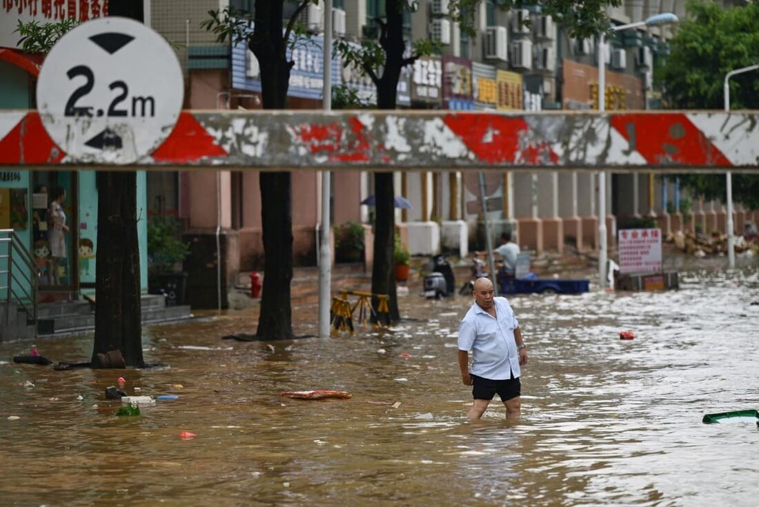 Um homem caminha por uma rua inundada em Zhongshan, na província de Guangdong, no sul da China, em 17 de junho de 2025.