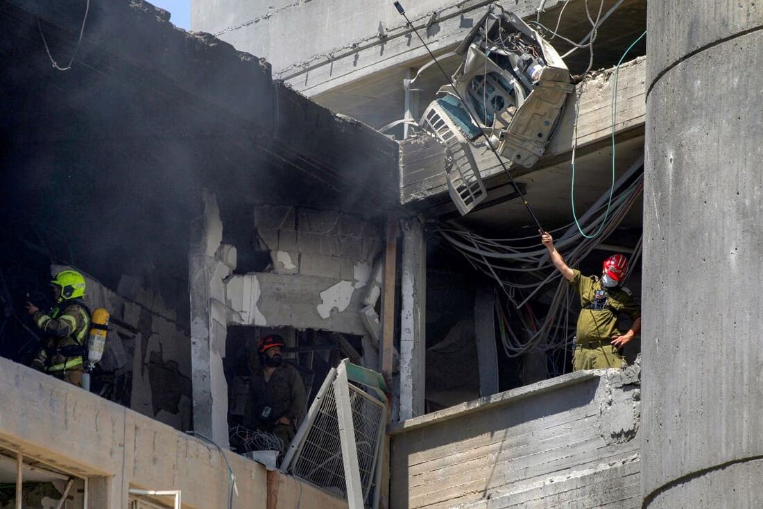 Socorristas inspecionam um prédio fortemente danificado no Hospital Soroka em Bersheba, no sul de Israel