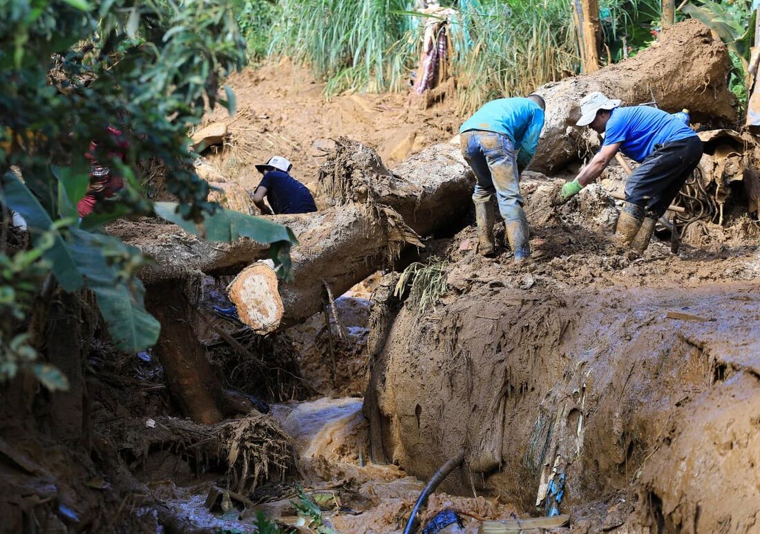 Homens trabalham na limpeza da área após um deslizamento de terra em Bello, Departamento de Antioquia, Colômbia, em 25 de junho de 2025.