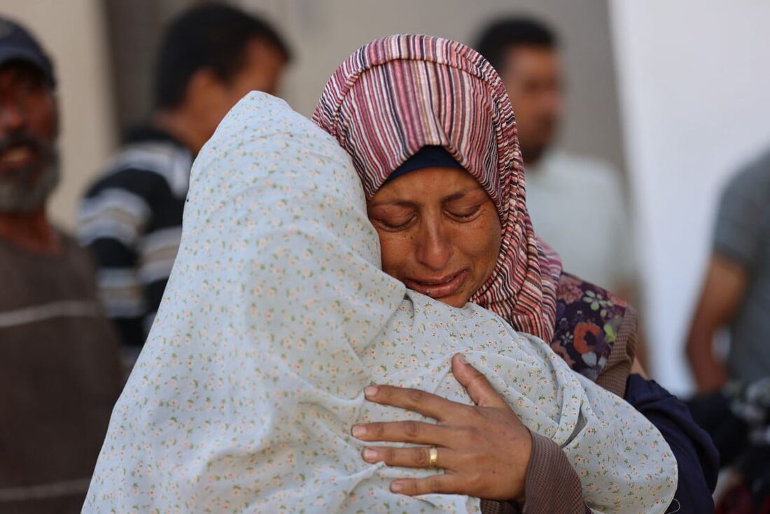 Mulheres palestinas choram do lado de fora do hospital Al-Shifa na Cidade de Gaza
