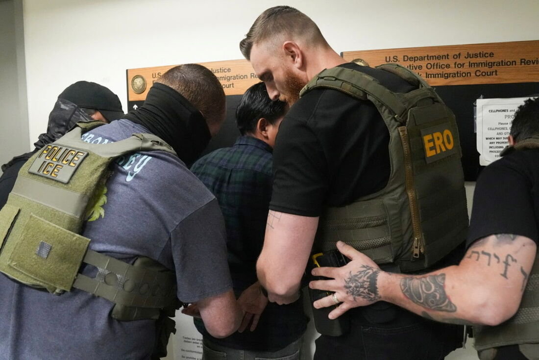 Um imigrante não identificado é detido por agentes do Serviço de Imigração e Alfândega dos EUA (ICE)