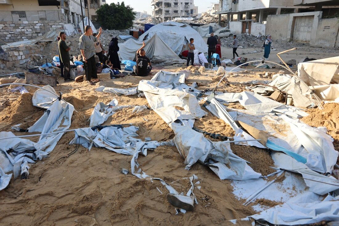 Famílias palestinas se reúnem após o exército israelense atacar as tendas de deslocados no bairro de Al-Rimal, ao norte da Cidade de Gaza, em 28 de junho de 2025