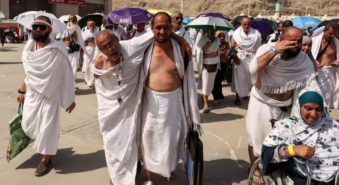 Homem afetado pelo calor é ajudado por outro enquanto muçulmanos chegam para peregrinação do hajj, perto da cidade sagrada de Meca, na Arábia Saudita, em 2024