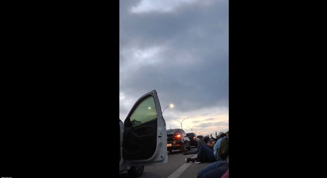 Condutores e passageiros de carros estacionados na via devido ao tiroteio