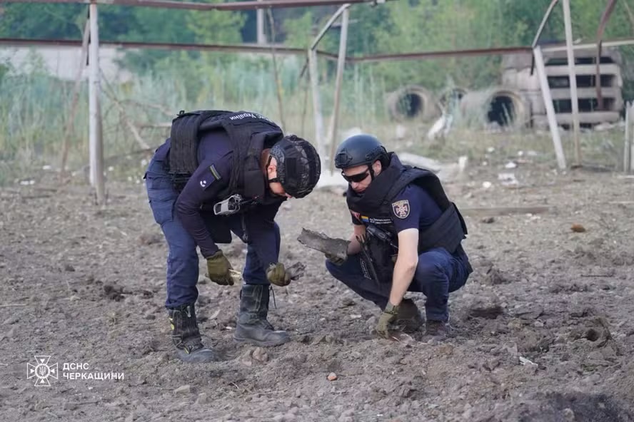 Soldados ucranianos recolhendo fragmentos em um local de ataque russo na cidade de Smila, região de Cherkasy, durante a invasão russa da Ucrânia