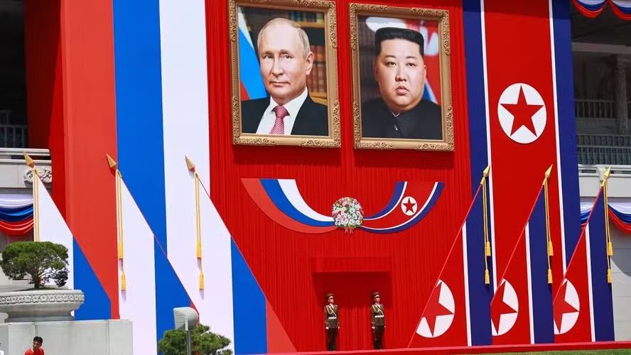 Dois guardas sob os retratos do líder norte-coreano, Kim Jong Un, e do presidente da Rússia, Vladimir Putin, durante visita do russo