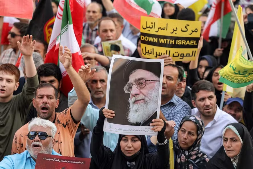 Manifestante levanta foto do líder supremo do Irã, Ali Khamenei, durante protesto em solidariedade ao regime em Teerã 