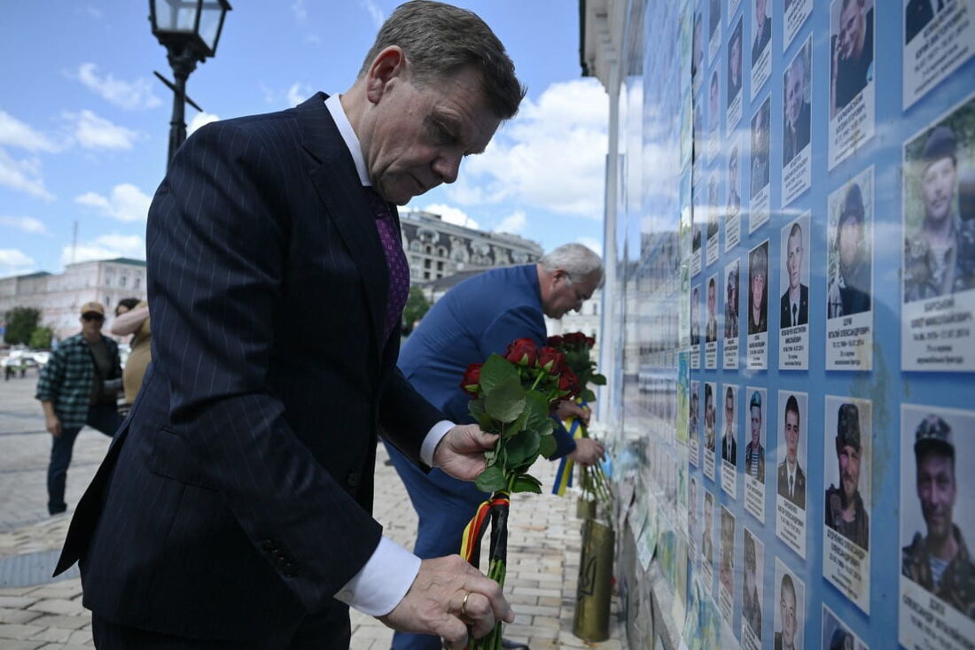 O Ministro das Relações Exteriores da Ucrânia, Andriy Sybiga (dir), e o Ministro das Relações Exteriores da Alemanha, Johann Wadephul (esq), depositam flores no Muro da Memória dos Defensores Ucranianos Mortos