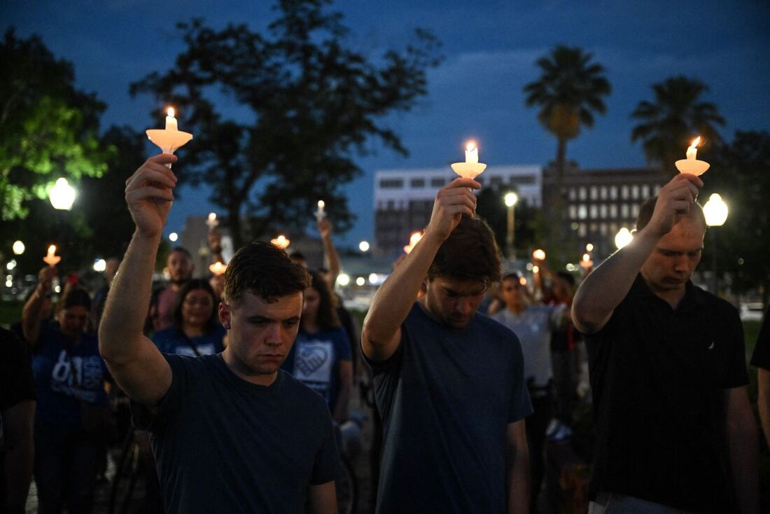 Pessoas seguram velas enquanto participam de uma vigília pelas vítimas das enchentes no fim de semana de 4 de julho, no Travis Park, em San Antonio, Texas
